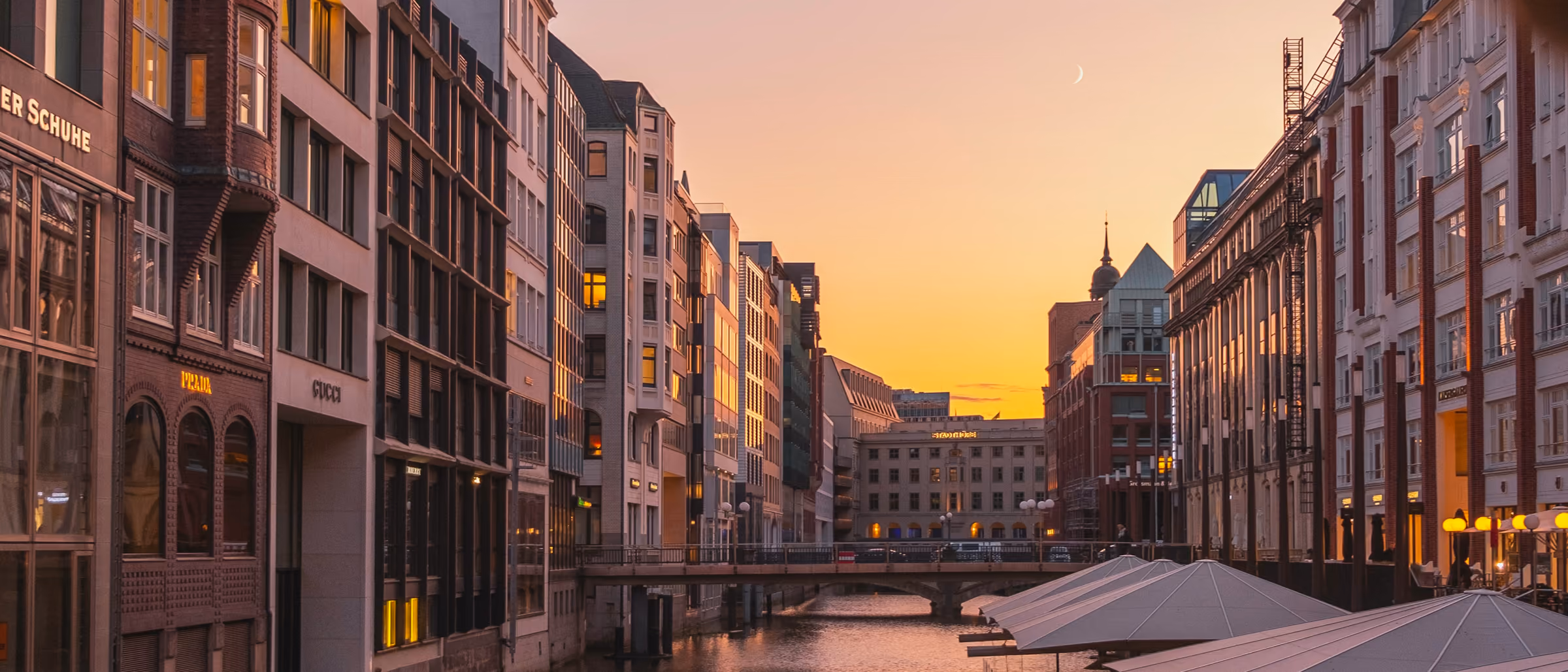 Fleet in der Hamburger Innenstadt im goldenen Abendlicht, die Häuserfronten spiegeln sich im Wasser
