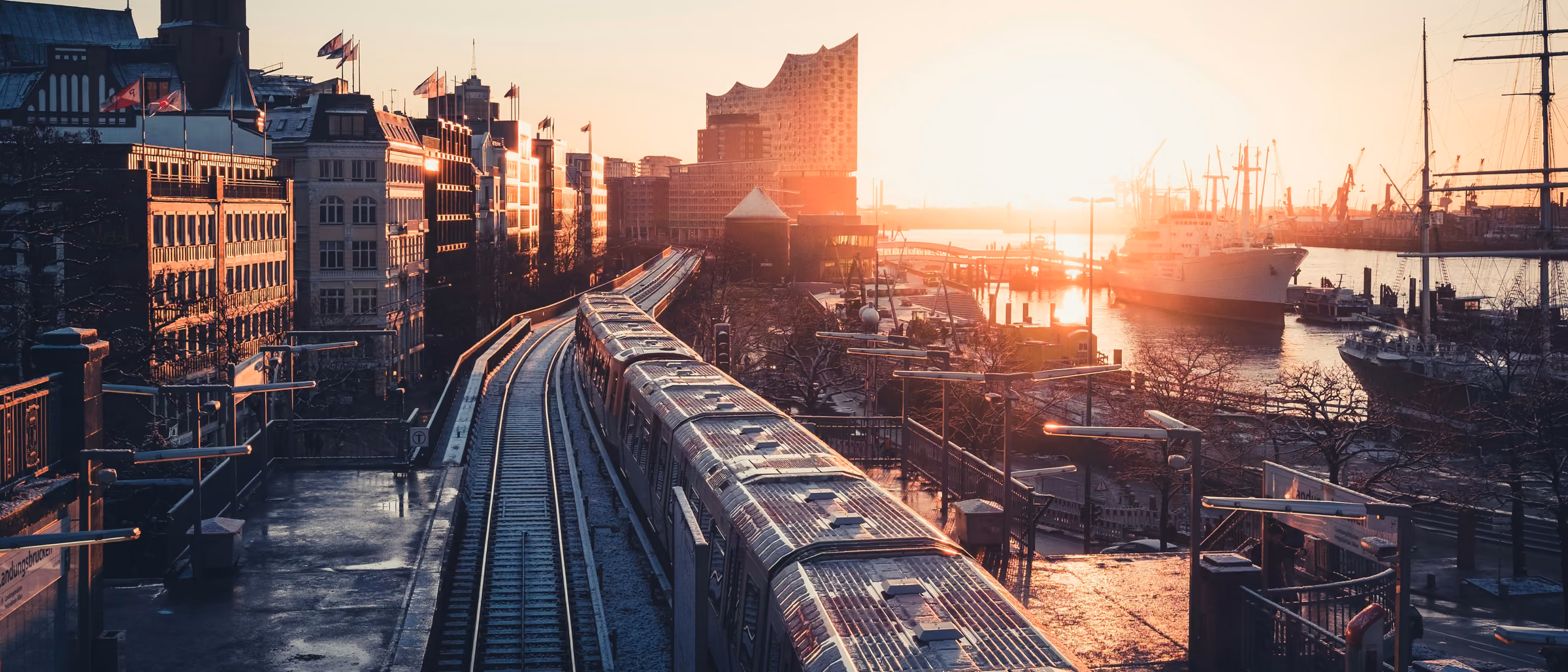 Blick über Gleise und Hafenanlagen in Hamburg bei Sonnenuntergang