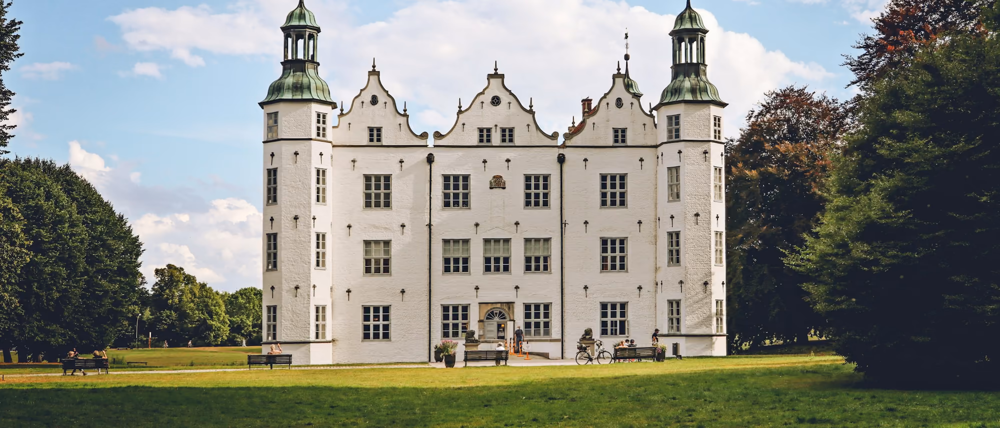 Schloss Ahrensburg hinter einer Wiese bei sonnigem Wetter